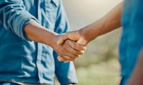 two men shaking hands outside
